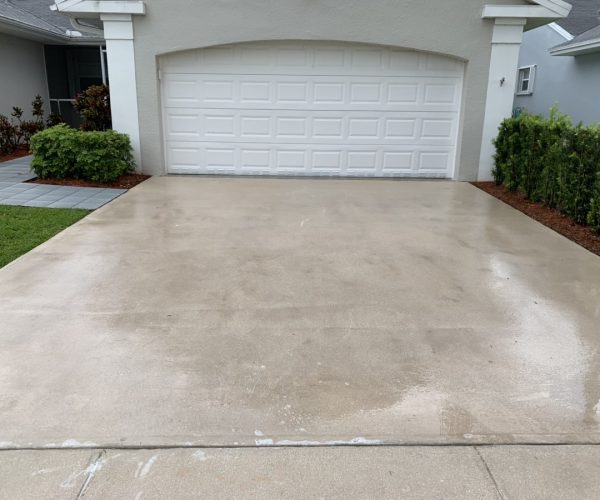 clean concrete in front of white garage door